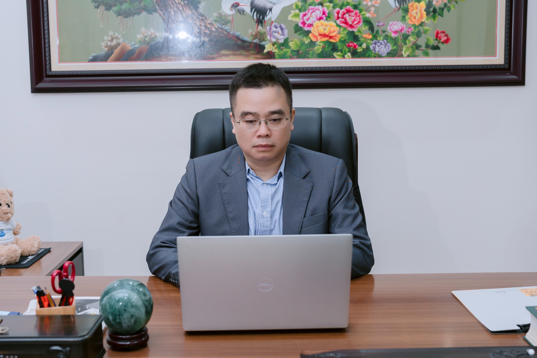 Binh Ba Ngo seated at his desk working on a laptop.